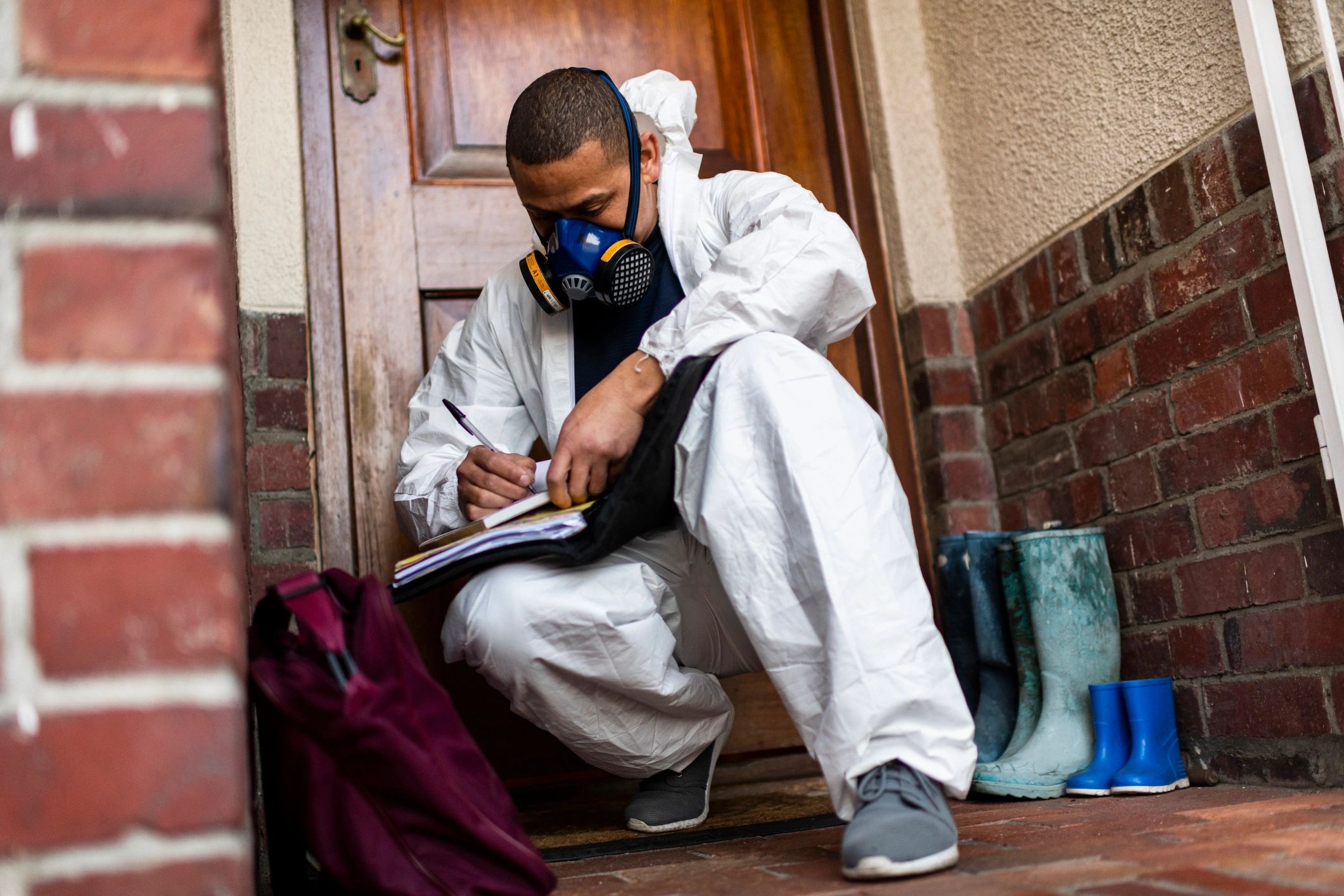 Pest control technician in protective equipment performing an on-site inspection