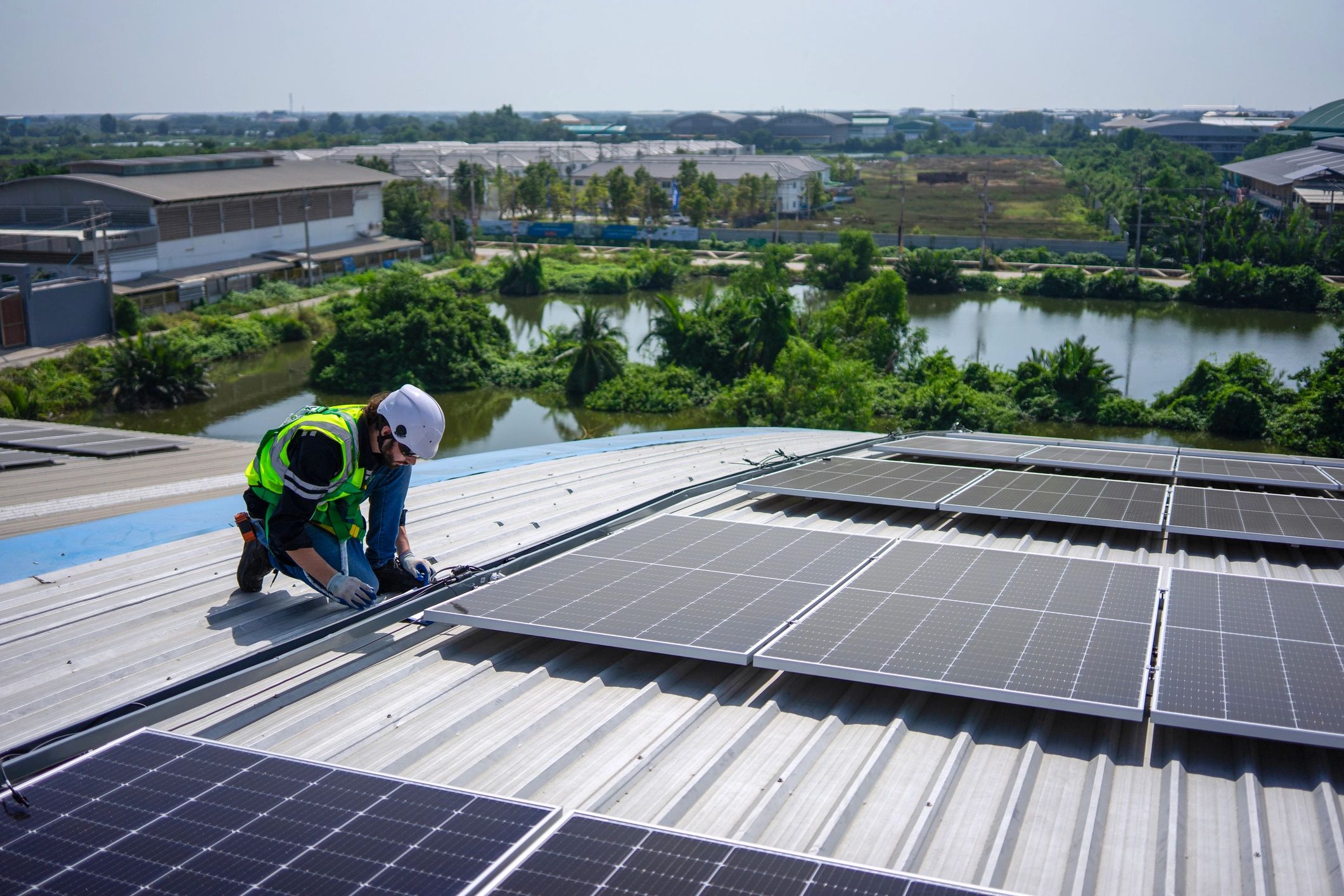 Technician inspecting electrical equipment on a commercial rooftop
